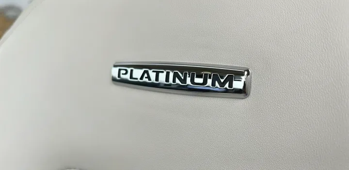 Luxurious 'PLATINUM' emblem on a light, textured interior surface, suggesting a premium rv rental experience.. Ford Ford Expedition 2021