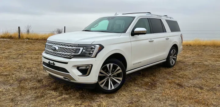 White Ford Expedition SUV, a large and comfortable vehicle in a field. Explore spacious travel options like an rv rental.. Ford Ford Expedition 2021