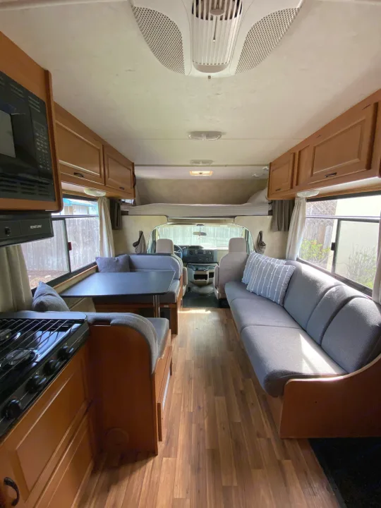 Inside this rv rental: A welcoming motorhome interior with a kitchen, dinette, comfortable sofa, and overhead bunk bed.. Thor Majestic 2013