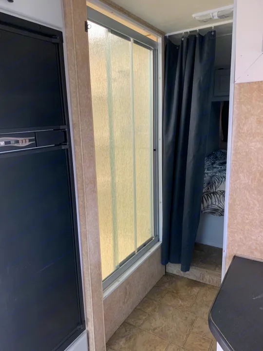RV rental: Interior view of shower with black curtain & frosted glass door, adjacent to a countertop and black appliance.. Other Other 2008