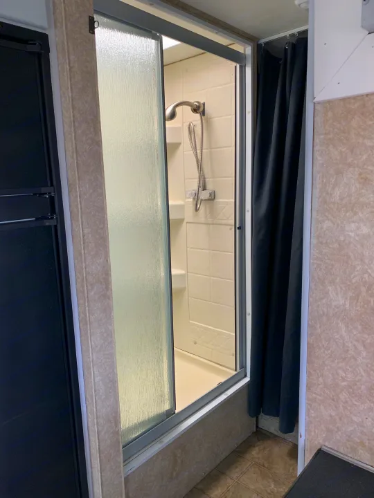 Compact shower and refrigerator in an RV rental interior, showcasing the efficient use of space.. Other Other 2008