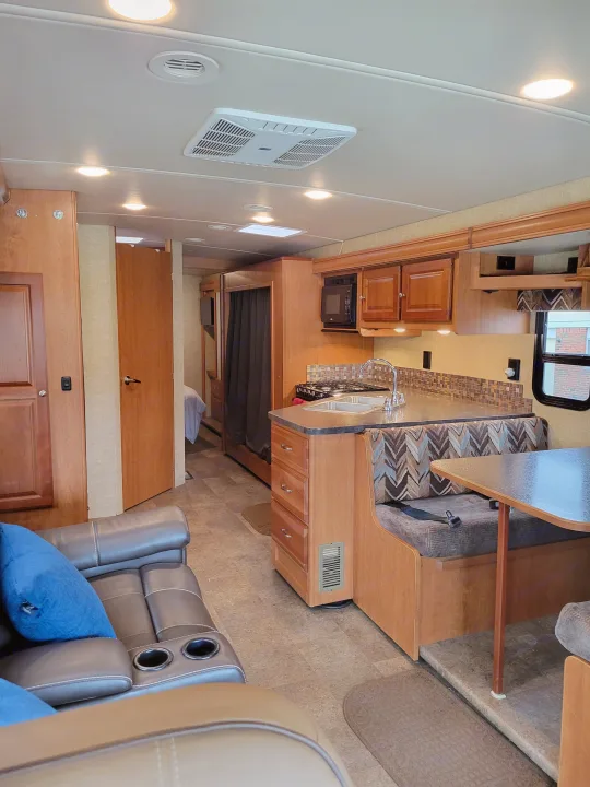 Spacious and modern RV rental interior featuring a full kitchen, comfy living area, and dining booth. Perfect for travel.. Winnebago Vista 2018