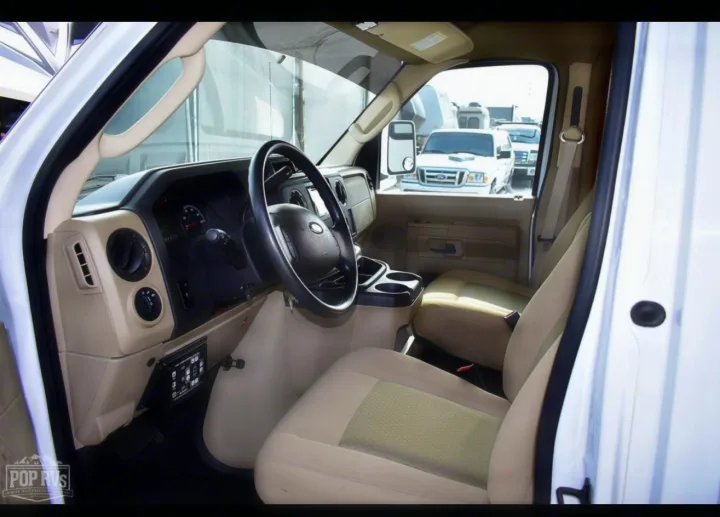 Step inside this RV rental's van cockpit. View the driver's area with steering wheel, dash, controls, and comfortable seats.. Itasca Spirit 2014