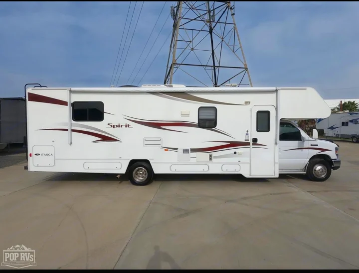 White Itasca Spirit RV for rv rental adventures. This Class C motorhome is parked on concrete with power lines in the background.. Itasca Spirit 2014
