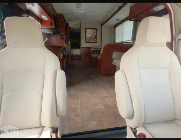 RV rental interior showing spacious living area from front seats, with dinette and kitchen beyond.. Itasca Spirit 2014