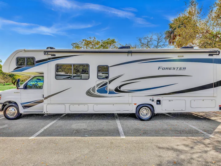 This sleek white Class C RV rental, a 'Forester' model, is parked outdoors on a bright day, ready for travel adventures.. Forest River Forester 2020