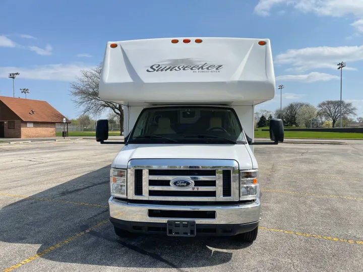 Head-on view of a white Sunseeker Class C RV rental on a Ford chassis, parked in a sunny lot. Perfect for your next trip.. Forest River Sunseeker 2013