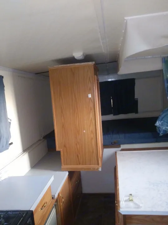 RV rental interior showcasing light wooden cabinets, countertops, and a dinette/bed area. Clean and ready for adventure!. K-Z Manufacturing Coyote 2002