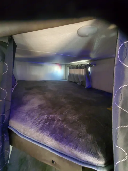 Cozy RV rental bunk bed interior with plush mattress and privacy curtains, ideal for comfortable travel.. Forest River Cherokee Grey Wolf 2021