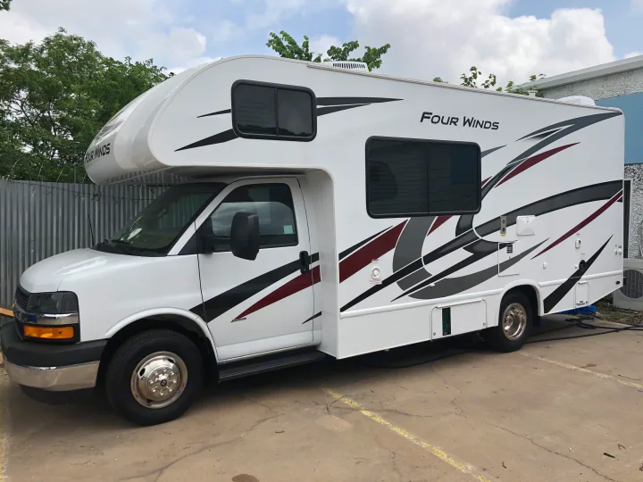 Explore with this white Four Winds RV rental, a Class C motorhome with sleek graphics, ready for your next trip.. Thor Four Winds 2022