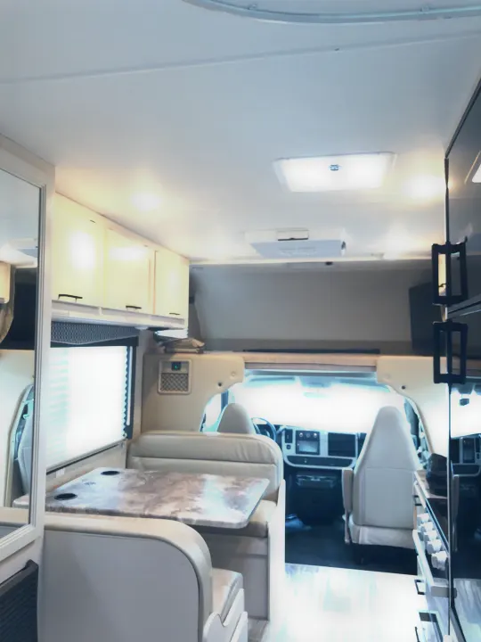 RV rental interior view: Spacious dinette, kitchen, and cockpit clearly visible. Ideal for comfortable travel.. Thor Four Winds 2022