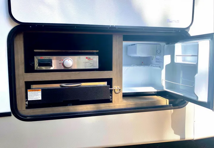 This RV rental boasts an outdoor kitchen with a Suburban griddle, pull-out drawer, and mini-fridge for convenient camping.. Keystone Cougar Half-Ton 2022