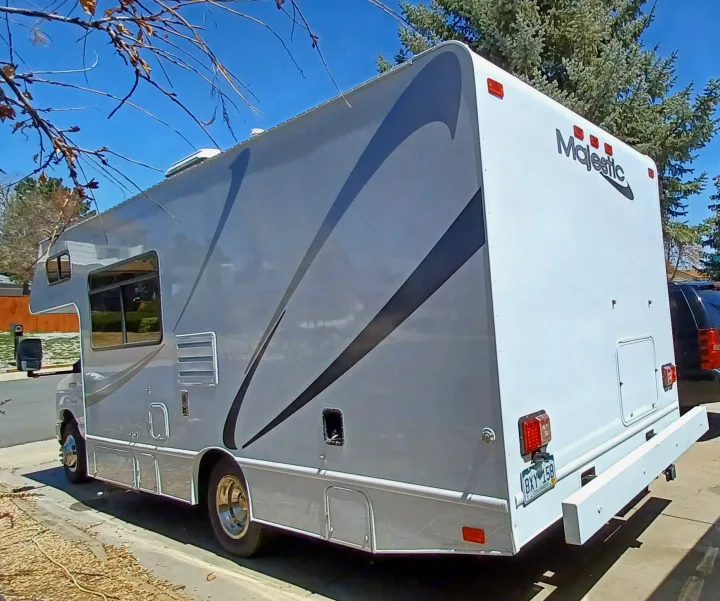 A clean white and gray Majestic RV rental is parked outdoors on a sunny day, ready for adventure.. Thor Majestic 2015