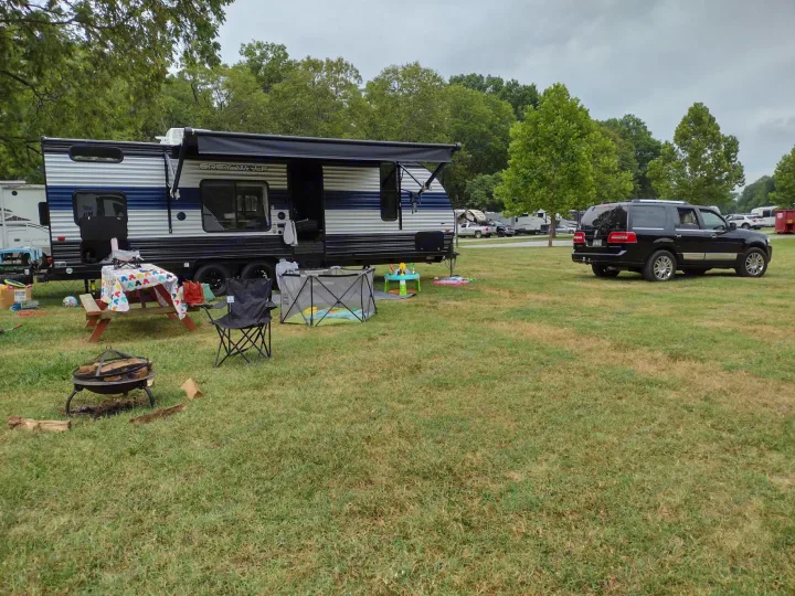 An RV rental in a spacious campground, featuring a picnic area, fire pit, and kids' play space.. Forest River Cherokee Grey Wolf Special Edition 2021