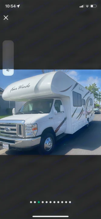 White Four Winds Class C RV rental parked on a sunny street. A spacious motorhome ready for adventure.. Thor Four Winds 2019