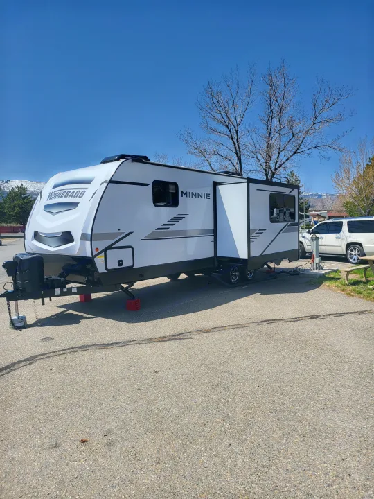 This white Winnebago Minnie travel trailer is ready for your RV rental getaway on a sunny day.. Winnebago Minnie Winnie 2022