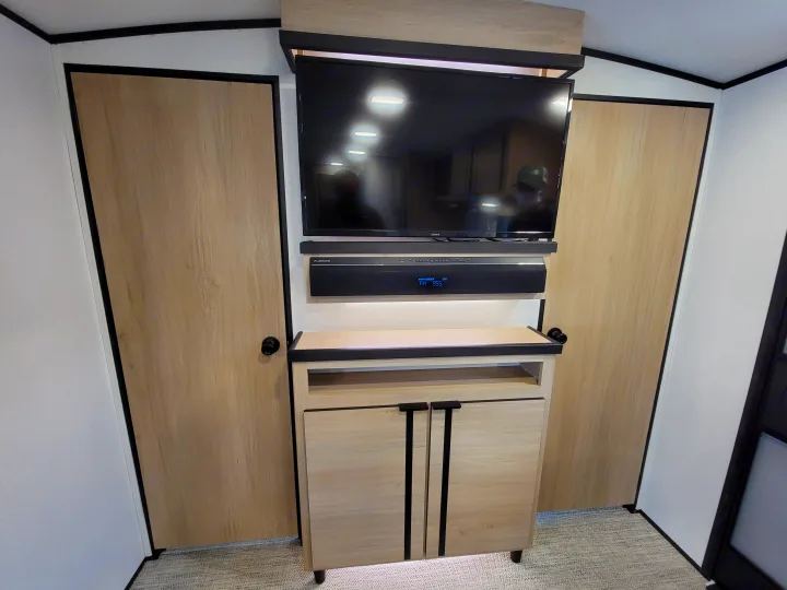 Spacious RV rental living space featuring a sleek entertainment console, TV, soundbar, and built-in closets.. Cruiser Rv Corp Radiance 30ds 2021