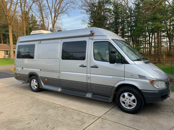 A silver Mercedes-Benz Sprinter 2500 camper van, parked on a concrete driveway, ready for rv rental.. Roadtrek Roadtrek Class B 2007