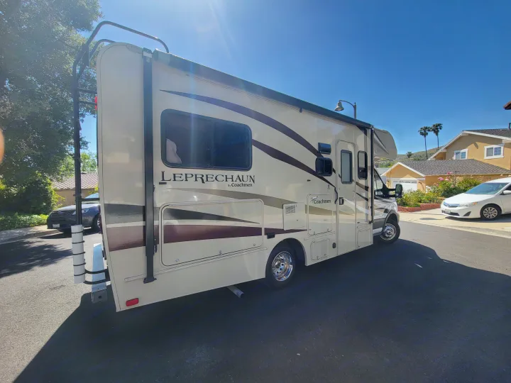Spacious Leprechaun Class C RV rental. This beige and brown motorhome is parked on a sunny day, ready for adventure.. Coachman Leprechaun 2018