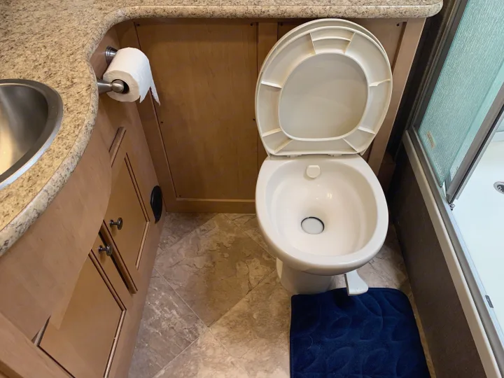 RV rental bathroom featuring a clean toilet, sink, and shower. Essential for comfortable travel.. Thor Windsport 2017