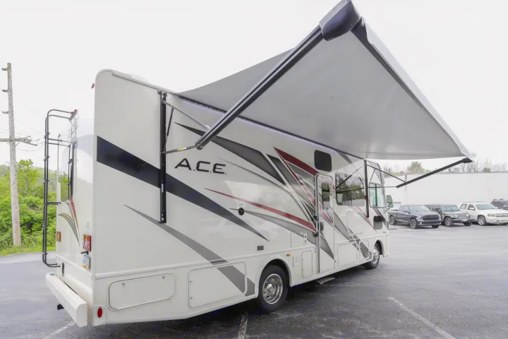 This cream-colored A.C.E. **RV rental** features an extended awning with LED lights, ideal for outdoor travel.. Thor Motor Coach A.C.E 2022