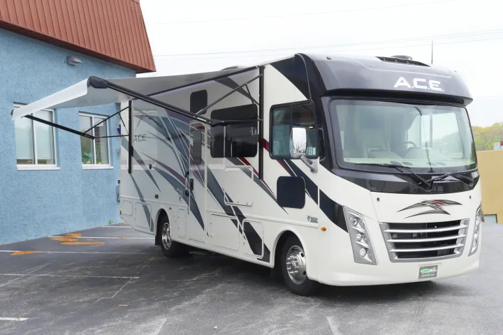 A white and black ACE Class A motorhome with an extended awning, perfect for your next rv rental adventure.. Thor Motor Coach A.C.E 2022