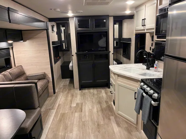 Bright, modern RV rental interior featuring a full kitchen, comfy living area, and entertainment system.. Jayco Jay Flight 2022