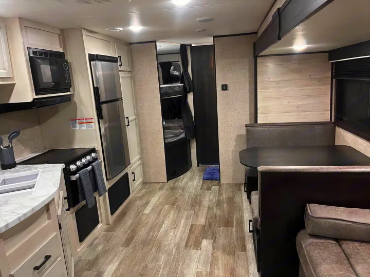 Explore this modern RV rental interior! Features include a well-equipped kitchen, dining space, and cozy bunk beds.. Jayco Jay Flight 2022