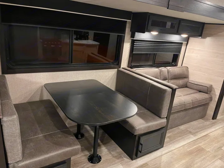 Spacious RV rental interior featuring a cozy dinette with booth seating and a comfortable sofa, ideal for road trips.. Jayco Jay Flight 2022