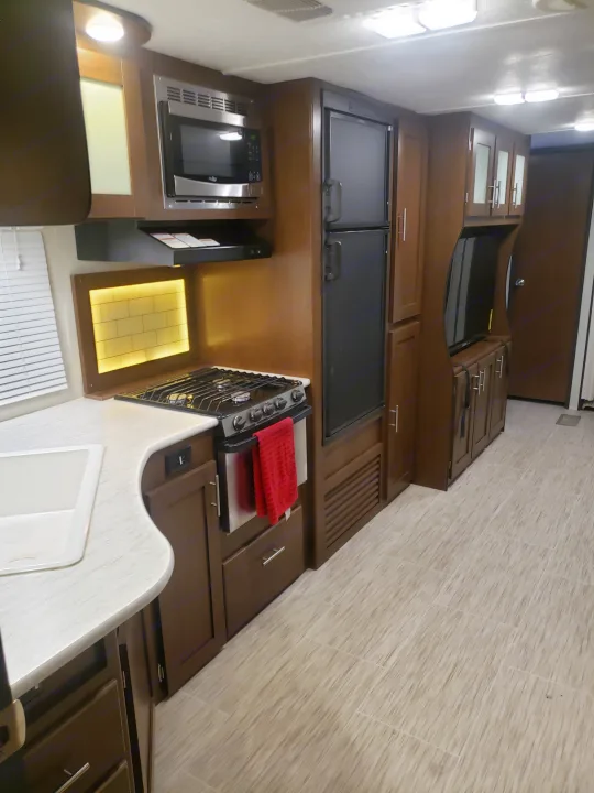 Spacious RV rental kitchen with modern appliances, ample storage, and comfortable interior design.. Avenger ATI 2020
