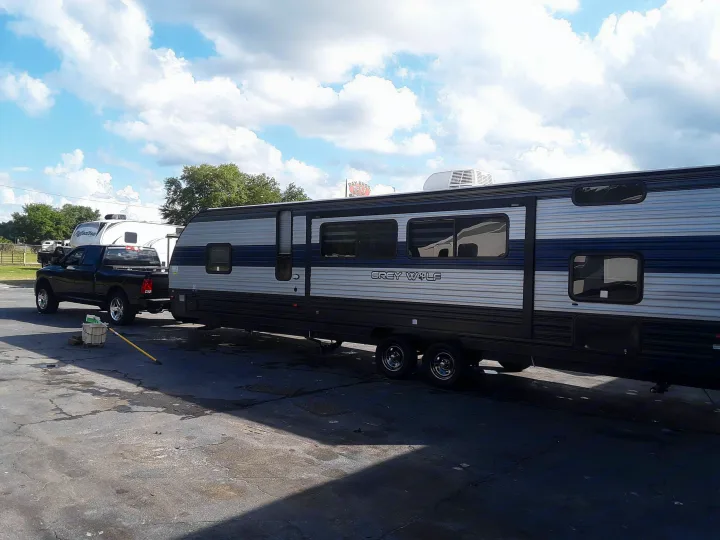 Black pickup truck hitched to a Grey Wolf travel trailer, an option for RV rental.. Forest River Cherokee Grey Wolf 2020