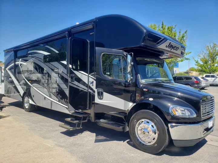 A striking black and grey luxury motorhome, parked outdoors, ready for your next rv rental adventure.. Jayco Seneca 37L 2021