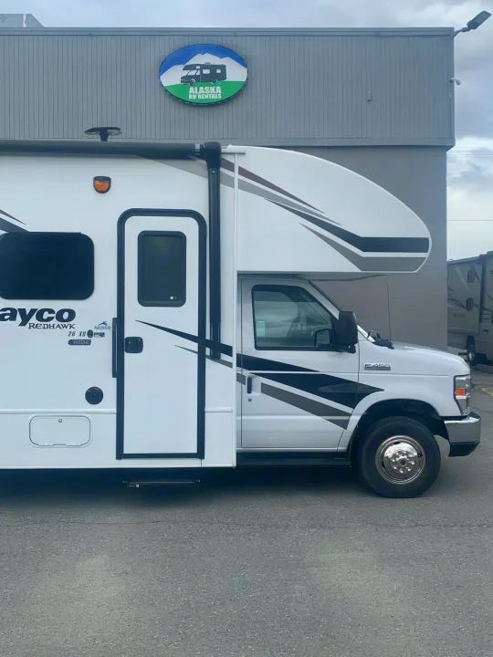 A white Jayco Redhawk Class C RV rental is parked at Alaska RV Rentals, ready for travel adventures.. Jayco Redhawk 2020