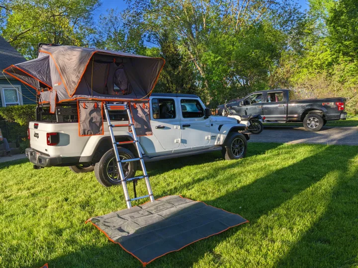 White Jeep Gladiator with a deployed rooftop tent & ladder on a lawn, perfect for an rv rental adventure & camping.. Jeep gladiator overland Jeep gladiator overland 2020