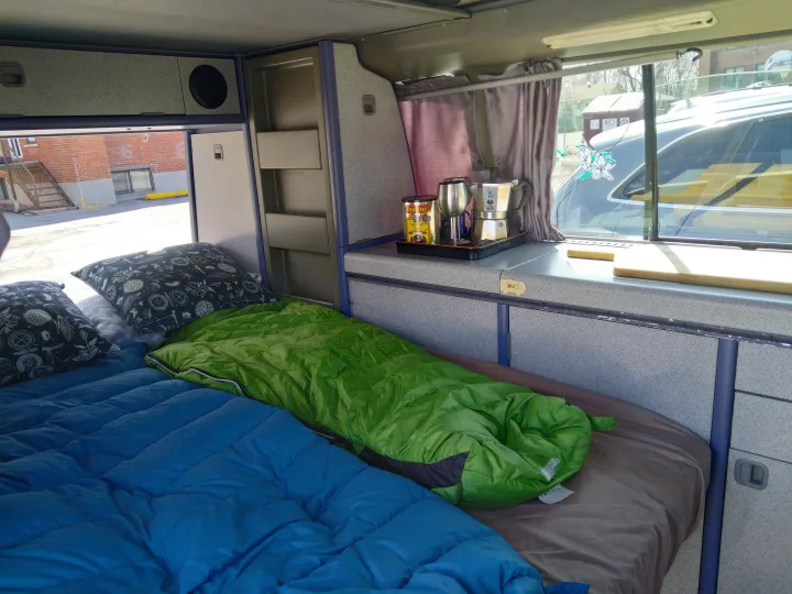 Inside an RV rental: a comfy bed, coffee maker, and organized storage make for a practical mobile home.. Westfalia T3 Westfalia 1993