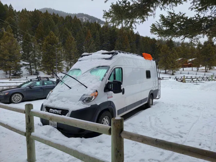 Snow-covered white RV rental van, perfect for winter adventures in the mountains.. Other Other 2021