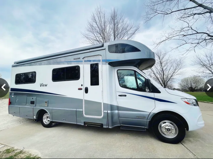 White & gray Winnebago View RV rental parked on pavement. This motorhome offers comfortable leisure travel.. Winnebago View 24J 2020