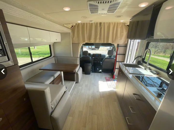 Spacious RV rental interior featuring a modern kitchen, cozy dinette, and front cockpit view, perfect for comfortable travel.. Winnebago View 24J 2020