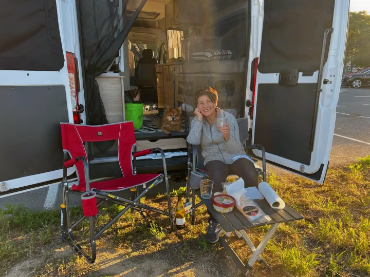 Woman, dog, and snacks outside a cozy RV rental at golden hour, embracing van life.. Winnebago Winnebago Solis 59P 2022