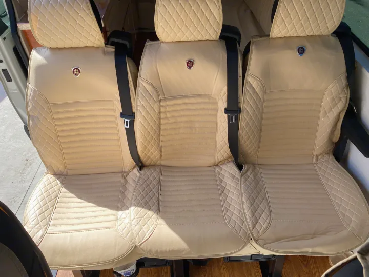 Inside an RV rental: three luxurious, diamond-stitched beige seats with seatbelts for comfortable travel.. Vanworks Mercedes Benz Sprinter 2021