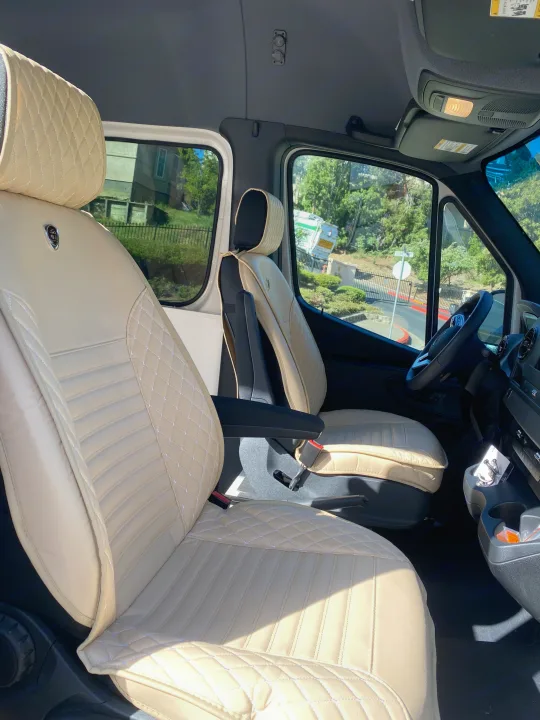 Inside this RV rental: plush, custom cream quilted front seats, offering comfort for your journey.. Vanworks Mercedes Benz Sprinter 2021