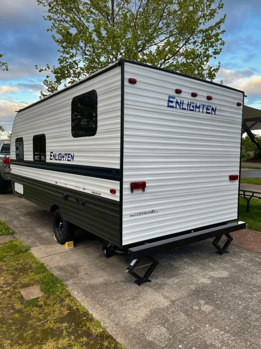 This Gulf Stream Enlighten RV rental is ready for camping adventures, parked and stabilized on pavement. Perfect for travel!. Gulf Stream Enlighten 18BH 2022