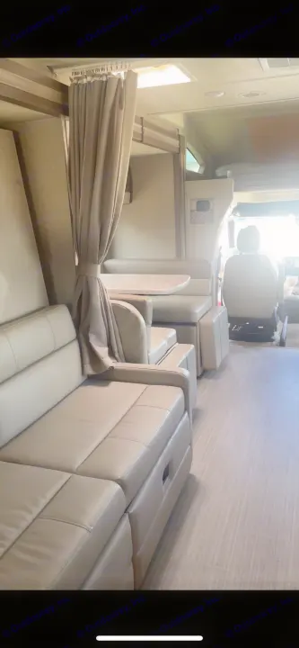 RV rental interior: cozy living space with a comfy sofa, dinette, and cockpit view. Ideal for road trips.. Thor Delano Sprinter 2020