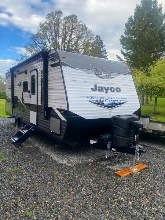 A Jayco Rocky Mountain Edition travel trailer, ideal for an RV rental, parked on gravel with awning extended.. Jayco Jay Flight SLX 8 2022