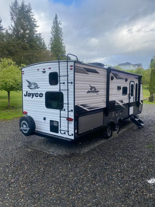 A white Jayco Jay Flight travel trailer, ideal for an RV rental, parked on gravel. Ready for your next adventure.. Jayco Jay Flight SLX 8 2022