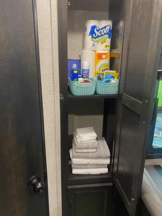 Inside an RV rental: a well-stocked cabinet with Scott RV toilet paper, Bounty paper towels, cleaning supplies & fresh towels.. Jayco Jay Flight SLX 8 2022