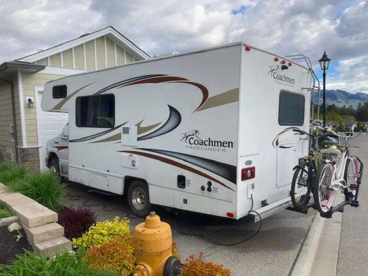 White Coachmen Freelander RV rental, a parked motorhome with two bicycles on a rear rack.. Coachman Freelander 2013