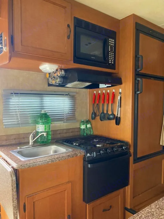 This RV rental offers a compact kitchen with microwave, stove, and sink. Fully equipped for convenient cooking on your camping trips.. Coachman Freelander 2013