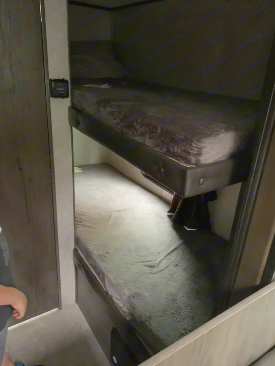 Cozy bunk beds in an RV rental interior, featuring dark mattresses and a visible "EXIT" sign for a compact sleeping area.. Jayco Jay Flight 2020