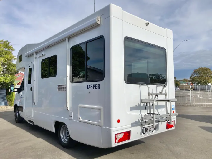 This white RV rental, named 'Jasper', features a bike rack, ready for scenic road trip adventures.. Mercedes-Benz Sprinter 2018